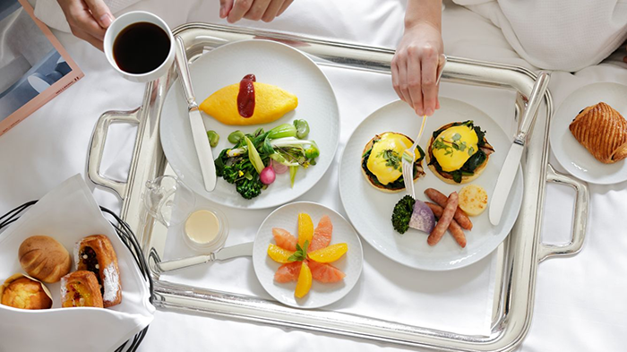 Room service at The Ritz-Carlton, Tokyo featuring Eggs Benedict, a Japanese Omelette, fresh fruit, and pastries.