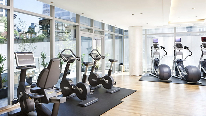 The Rosewood Hotel Georgia's fitness center. Large windows allow plenty of natural light into the space.