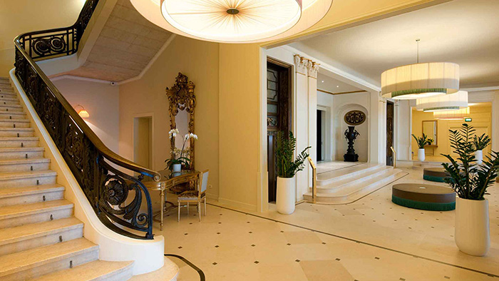 A hallway at the Savoia Excelsior Palace. There are some interesting circular stools on the ground to the right of some steps.