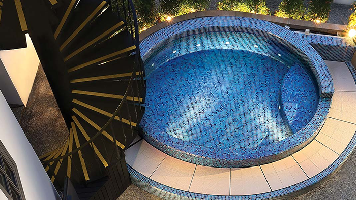The Scarlet hotel's hot tub. A black and gold spiral staircase can be seen just left of the circular heated pool.