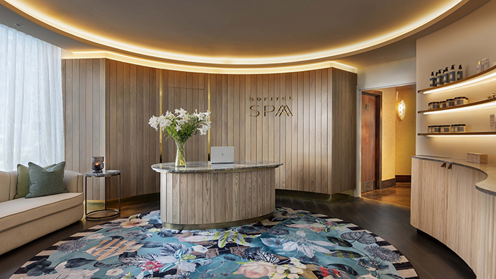 The reception area at the Sofitel Auckland Viaduct Harbour Hotel spa. A large vase full of white flowers is sitting on the front desk.