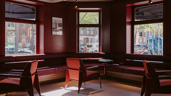 A lounge area on the ground floor of the Supernova Hotel in Rotterdam. The red furniture matches the color of the walls.