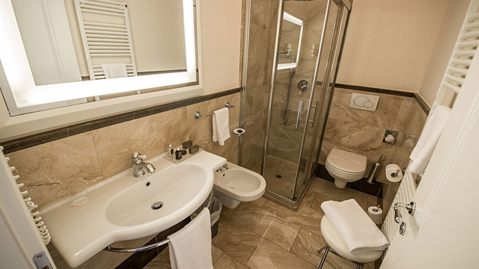 A bathroom attached to a guest room inside the Victoria Hotel Letterario. It features a bidet.