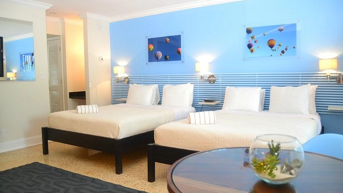 One of The Victoria Park Hotel in Ft. Lauderdale's guest rooms. This one has a light blue accent wall and two double beds.