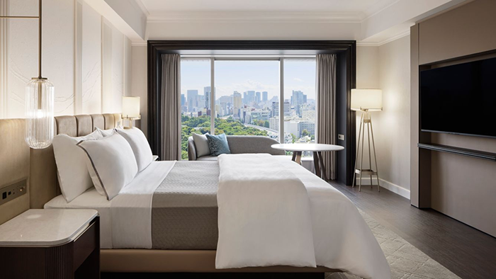 A guest room at The Westin Tokyo. There's a large window with a view of the city just past the bed.