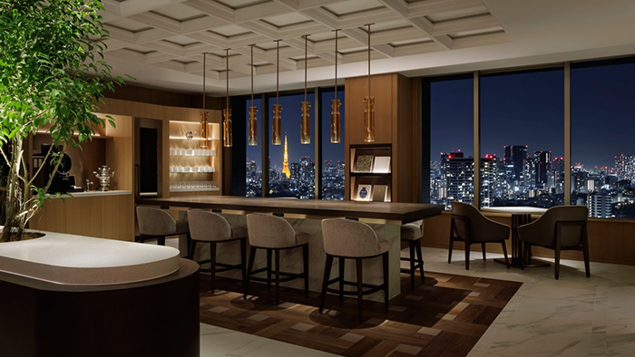 A common seating area inside The Westin Tokyo. A cityscape view is seen through the window, with Tokyo Tower clearly visible.